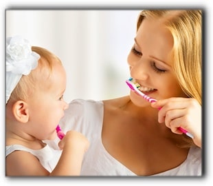 photo of mother and toddler brushing teeth