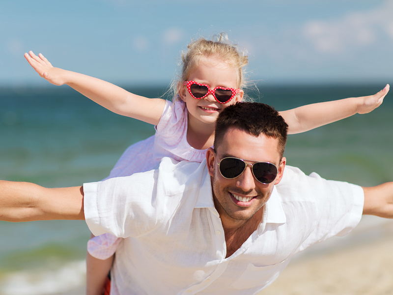 family, travel, vacation, adoption and people concept - happy father with little girl in sunglasses